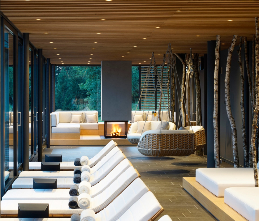 Extension Spa Area in Hotel "DAS TEGERNSEE" in white, with a cozy fireplace and big suspension sofas.